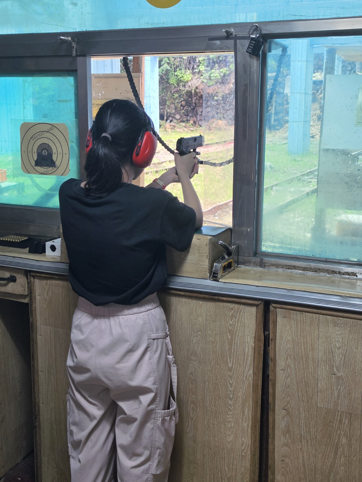청력 보호구를 착용하고 대유랜드 사격 체험 중인 방문객의 뒷모습