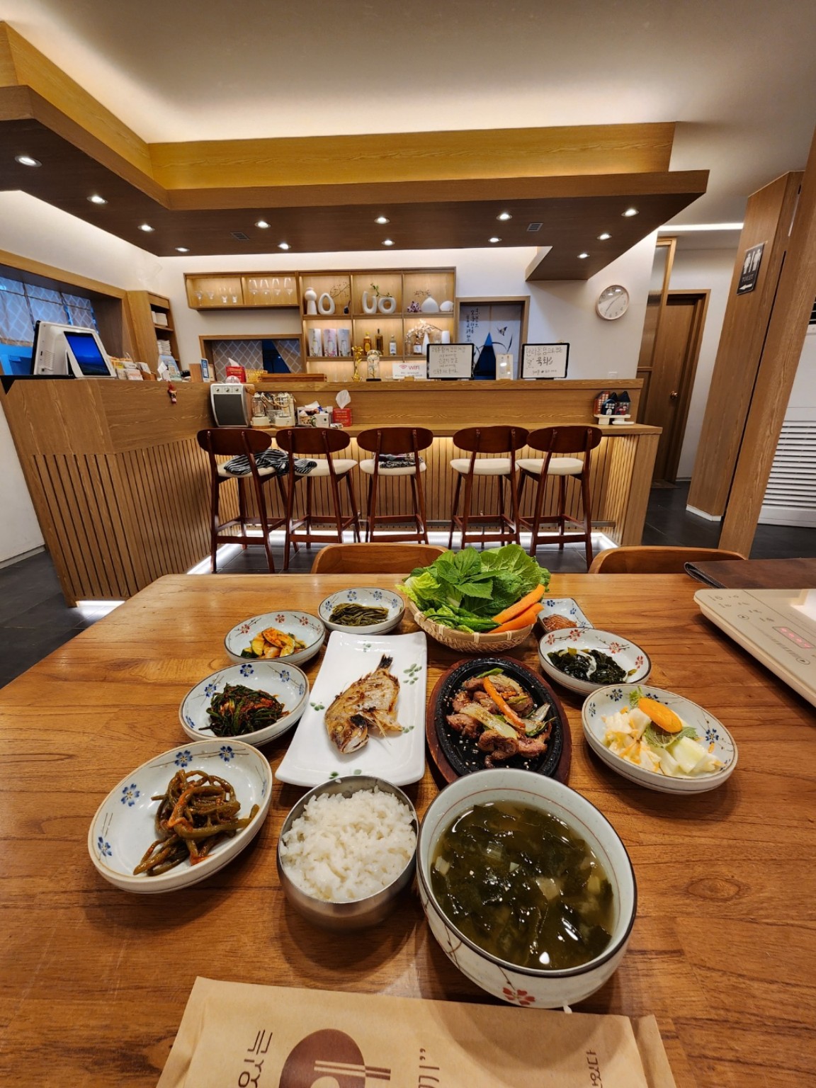 오로섬 한상에 차려진 생선구이와 흑돼지 요리, 국과 여러 반찬