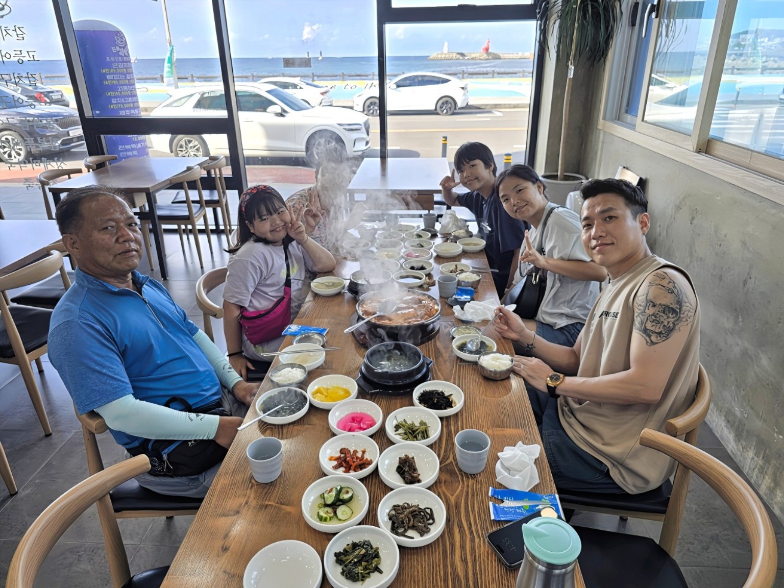 바다가 보이는 창가에서 조림을 즐기는 방문객들