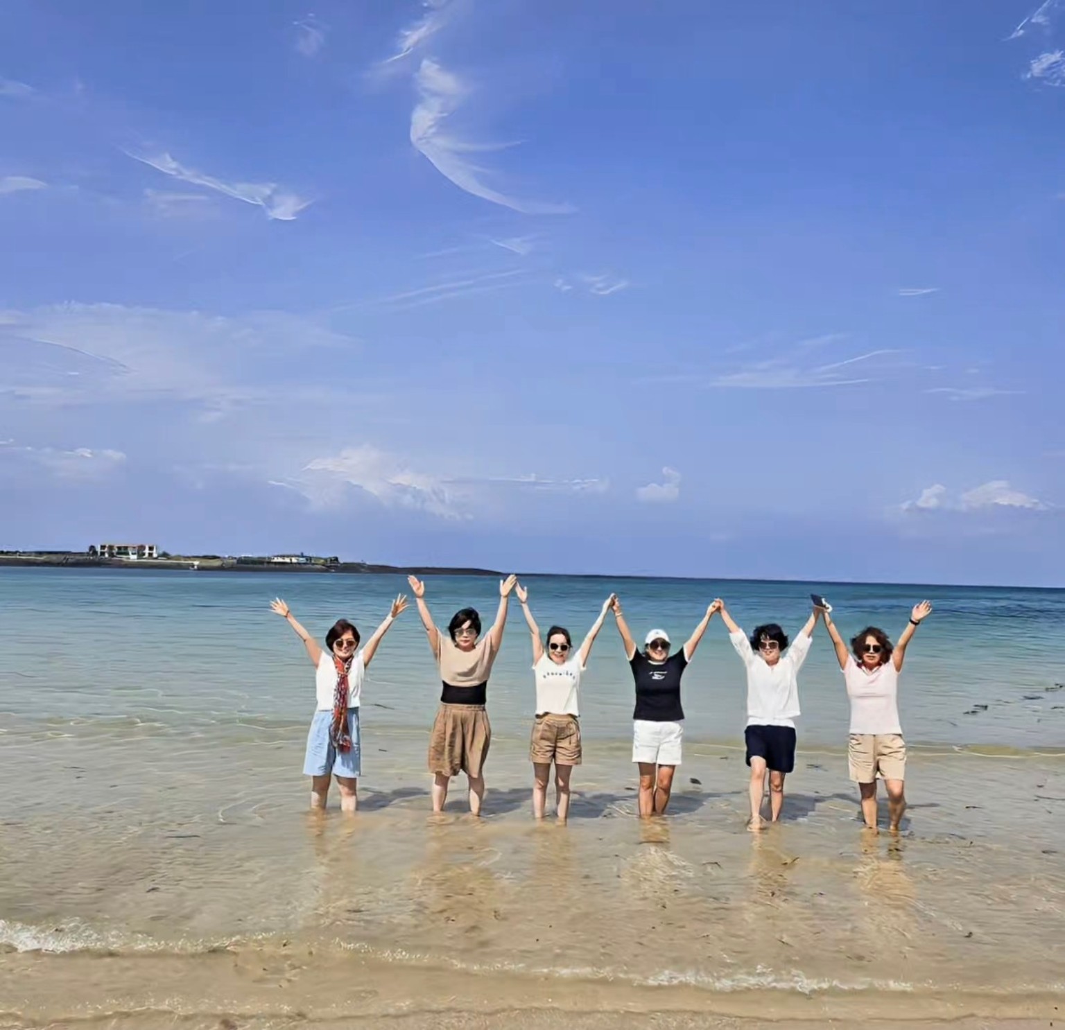 우도 해변에서 손을 들고 사진을 찍는 여행객들